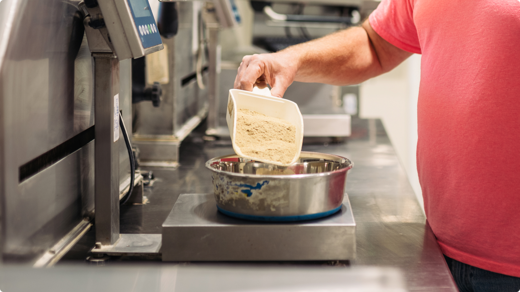 A Hill’s employee measuring ingredients on a scale